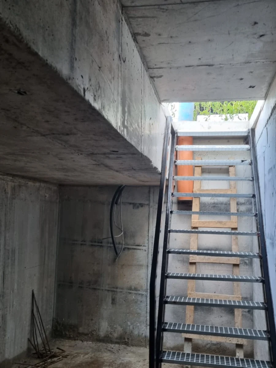 Beci terminat, cu scara metalică de acces montată și pereții finisați