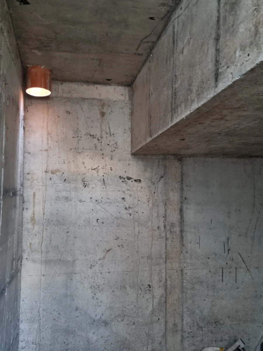 Beci din beton terminat, cu pereți finisați și o lampă de perete